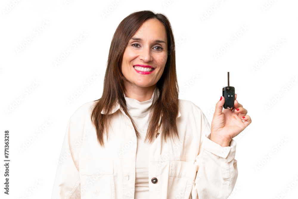 Middle-aged woman holding car keys over isolated background smiling a lot Middle-aged woman holding car keys over isolated background smiling a lot