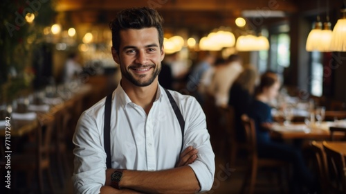 Handsome waiter standing in restaurant with arms crossed photo