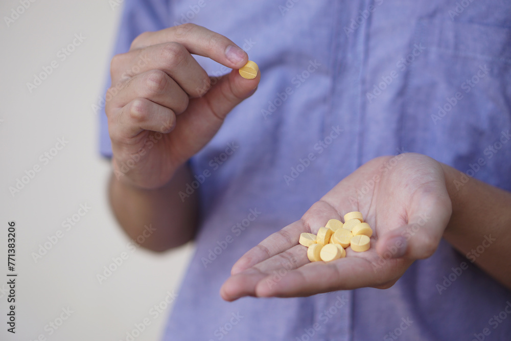 Selective focus on some yellow pain killer medicine pills on hands. Concept, Health care, treatment, remedy illness and self therapy at home. Taking overdose pills. Selective focus on some yellow pain killer medicine pills on hands. Concept, Health care, treatment, remedy illness and self therapy at home. Taking overdose pills.