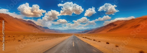 Open road with mountains on the horizon. Straight road cuts through desert, mountains in distance, under bright blue sky with wispy clouds, hinting at adventure in vast, open wilderness.