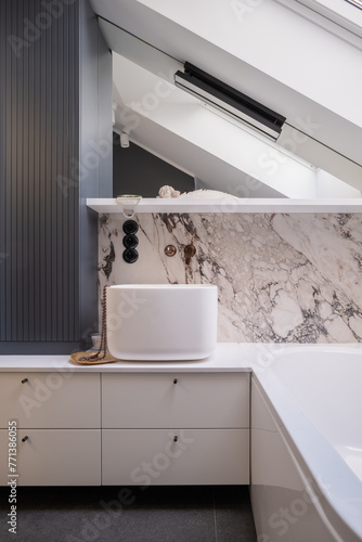 a bathroom with a sink and a bathtub under a skylight