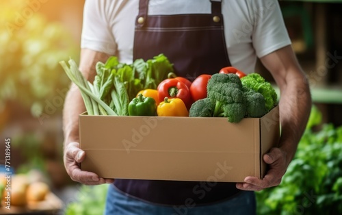 A close-up shot of a man in an apron delivering a box full of fresh, green vegetables, emphasizing healthy eating and organic farming