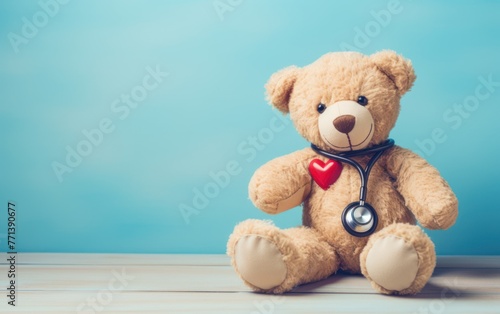 A cute teddy bear with a stethoscope presents an idea of pediatric care or children's health