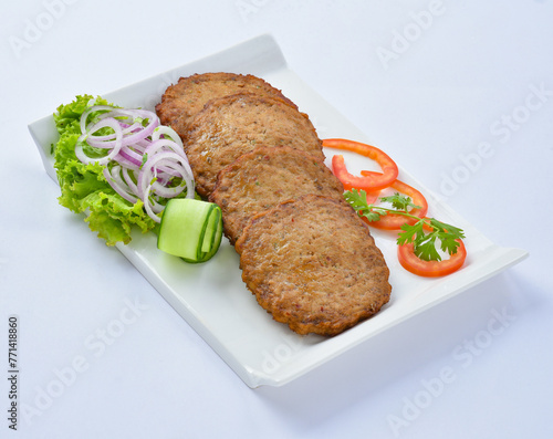 Chicken Chapli kebab or chapli kabab is a Pashtun-style minced kebab, usually made from ground beef, mutton or chicken with various spices in the shape of a patty.  photo