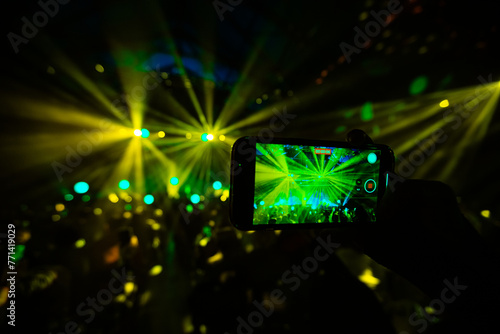 Hands holding phone and making photos on the concert