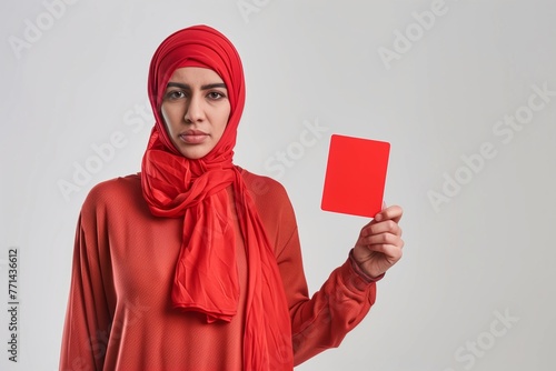 Woman with hijab showing red card against racism