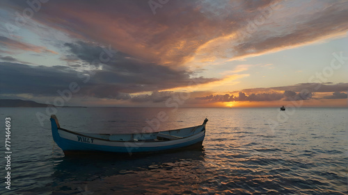 Two boats and the sea at sunset, and the sky behind them has clouds