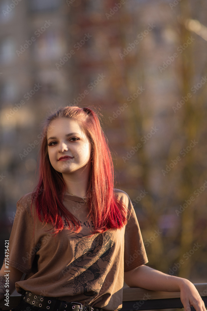 Fototapeta premium Portrait of a young red-haired girl outdoors in spring.