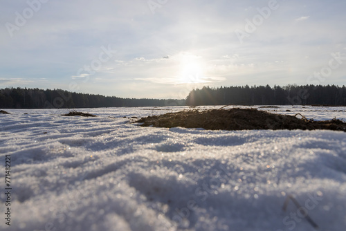 snow-covered plowed soil in the field in winter
