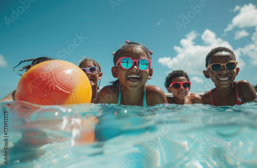 happy group of children in a swimming pool with a beach ball, wearing sunglasses and enjoying the summer