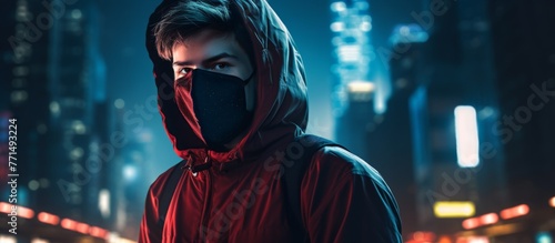 A fictional character wearing an electric blue helmet, red hoodie, and black mask stands against the darkness of the city at night, creating an intriguing piece of art in this entertainment event