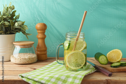 Infused water with lemon and cucumber on wooden table. Detox, diet, healthy eating or  weight loss concept background