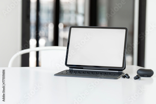 Mockup blank screen digital tablet with magic keyboard on white table.