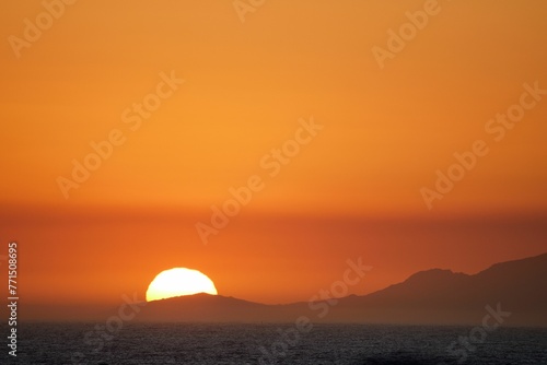 Mountains silhouetted against the vibrant sky at sunset. Simon's Town, Western Cape. © Wirestock