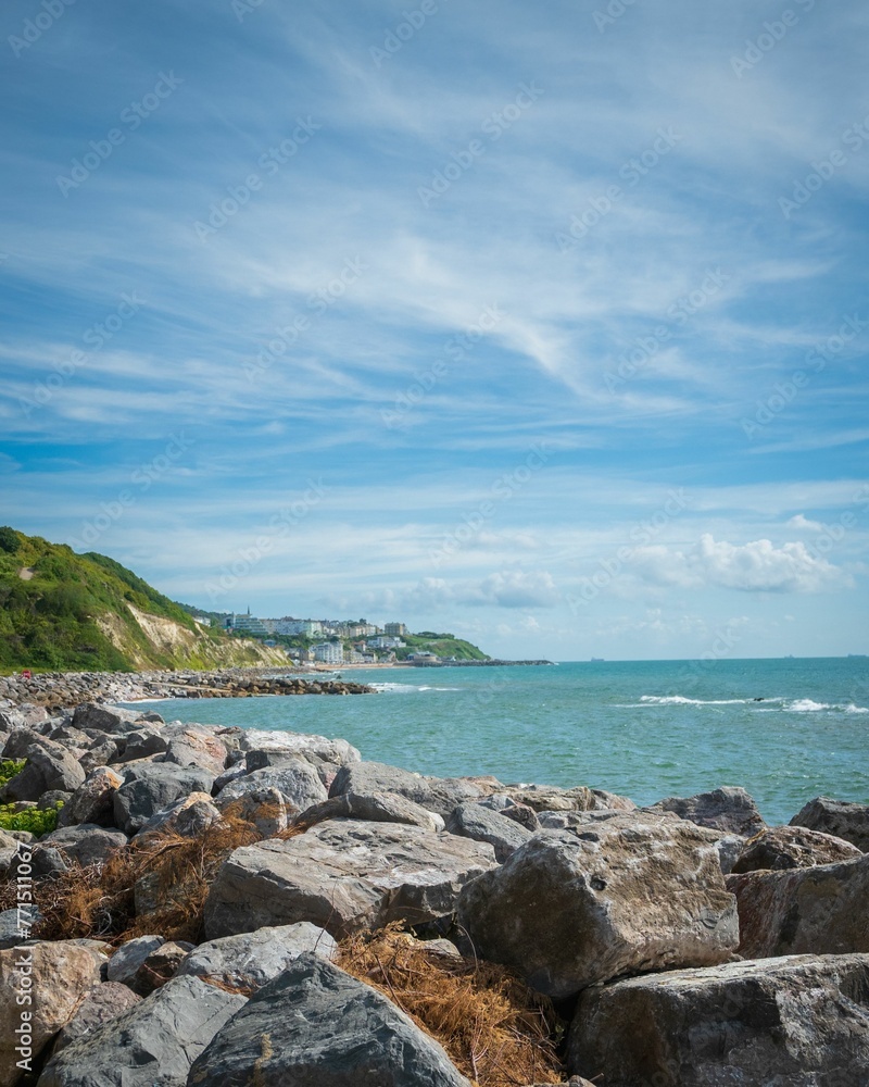 Scenic view of the rocky shoreline near the Steephill cove with buildings in the distance