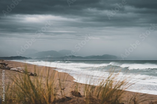 Shoreline of a sandy beach with clouds in the sky