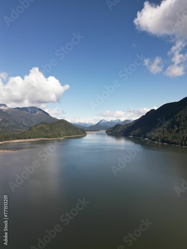 a view over the water of mountains and a river with mountains in the background