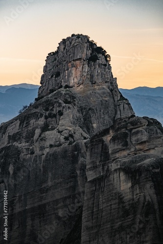 Vertical shot of a rock formation with a majestic sunset in Meteora, Greece.