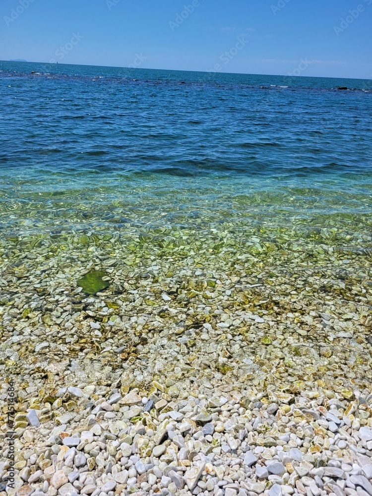 Obraz premium water and gravel on the beach near the shore of the lake