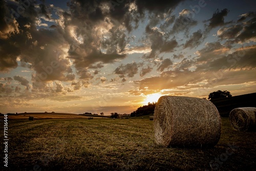 a hay roll in a rural field at sunset