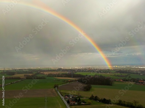 a rainbow is seen over the farmland in this view from a window