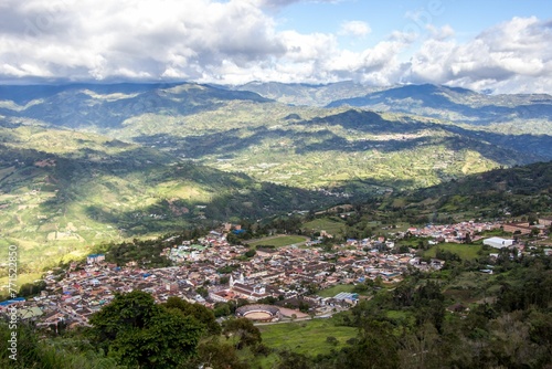 Aerial view of a town on green hills on a sunny day