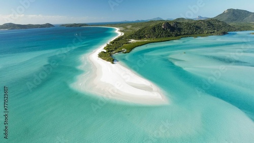 Aerial shot of a tranquil scene of a white sandy beach with crystal clear ocean water.