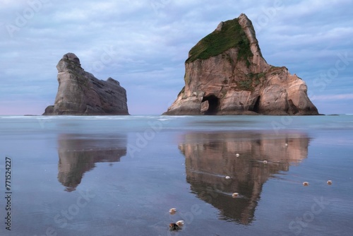 Landscape of two rocks in the middle of the sea reflected on the water surface