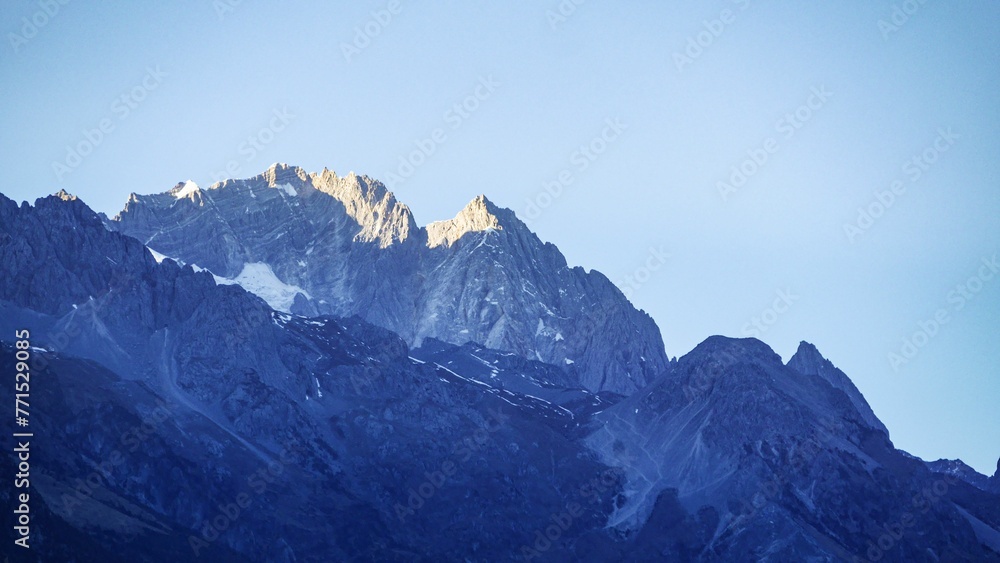 a mountain covered in snow with no tops and a blue sky