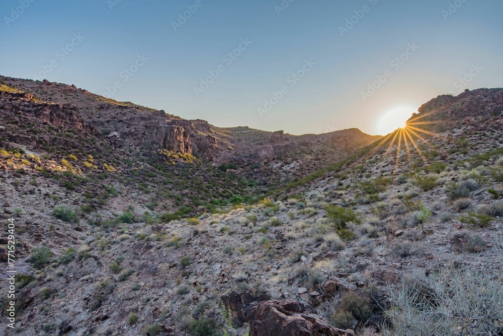Fototapeta premium the sun is setting on a mountain side as seen from an overlook