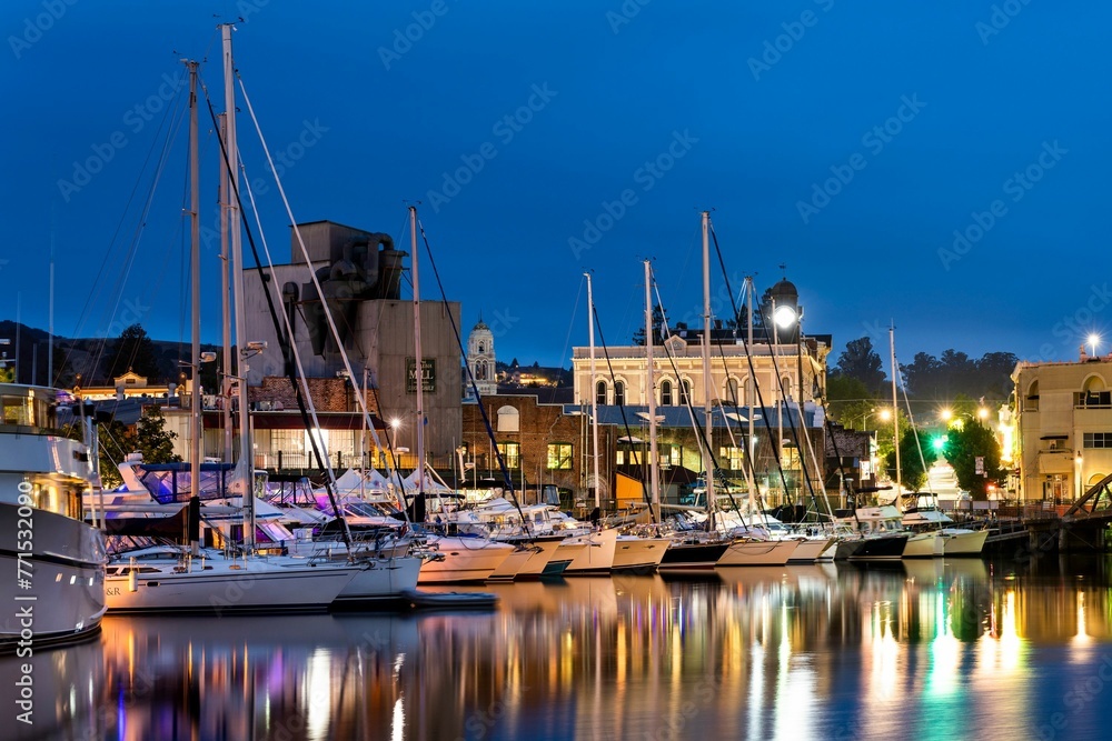 a group of small boats docked in a marina at night
