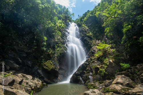 Stunning bride's pool waterfall cascades over a rock-strewn river, surrounded by lush green foliage