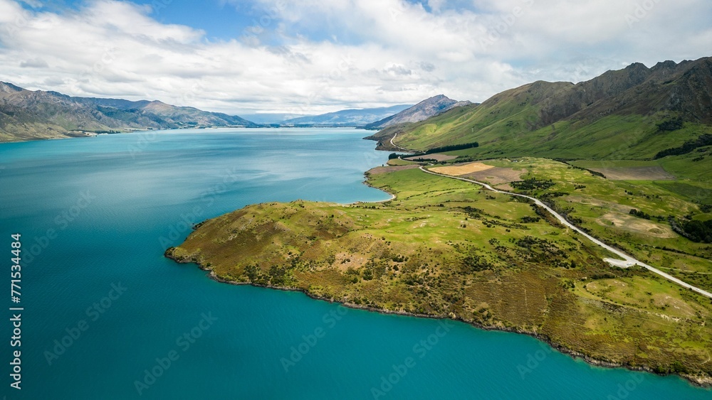 Aerial view of a glistening blue body of water surrounded by lush green mountains