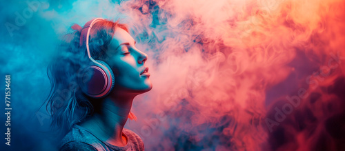 Chica con los ojos cerrados escuchando música con auriculares rodeada de humo de colores photo
