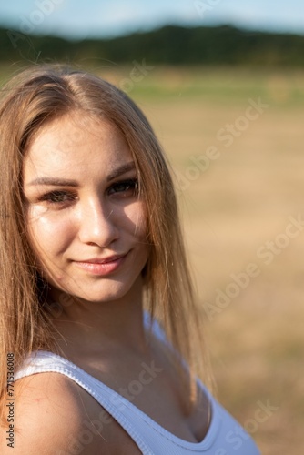 Youthful female stands in a picturesque outdoor setting, her expression thoughtful