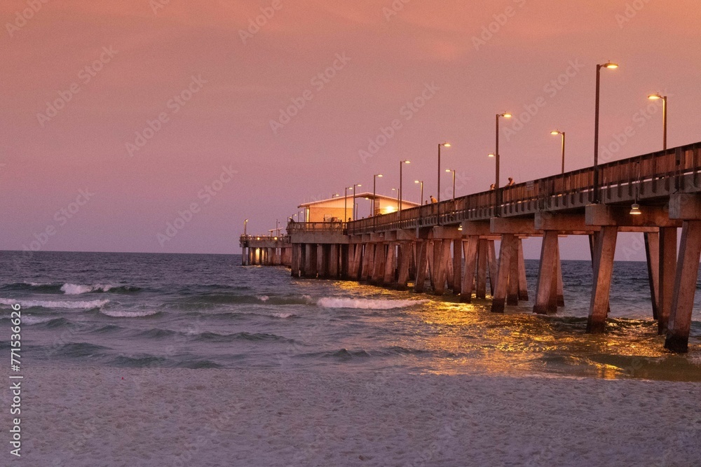 Dramatic sunset over the Gulf State Park Pier silhouetting a picturesque shoreline