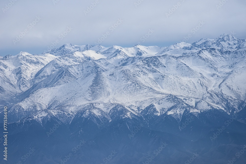 Scenic aerial view of snow-capped mountain peaks covered in fog.