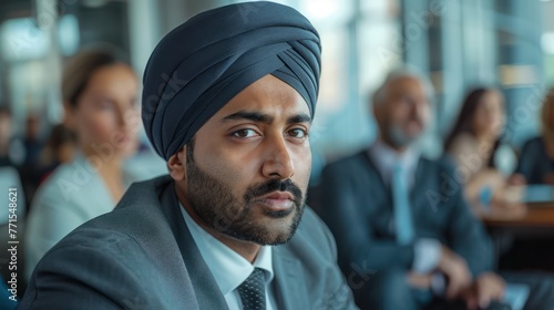 A young Sikh man wearing a traditional Sikh turban gets annoyed and looks away.