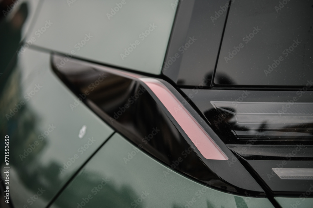 Tail lights closeup. The left rear light on a new modern electric sedan car. Modern concept super car exterior design detail - headlight. Back view. The concept of the future. Tail lights closeup. The left rear light on a new modern electric sedan car. Modern concept super car exterior design detail - headlight. Back view. The concept of the future.