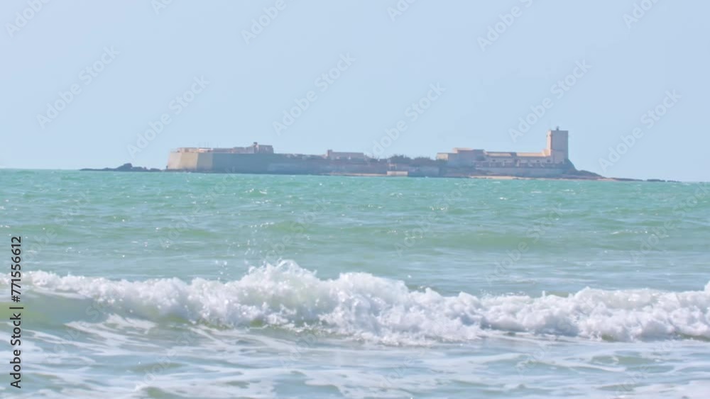 Shot of sea waves with an island and a huge building on it in the background. Shot of sea waves with an island and a huge building on it in the background.