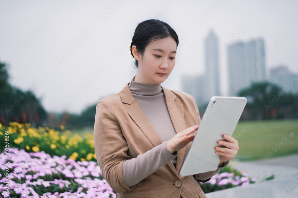 Professional Woman Using Tablet in Urban Park Professional Woman Using Tablet in Urban Park
