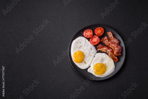 English breakfast with fried eggs, bacon, beans, tomatoes, spices and herbs