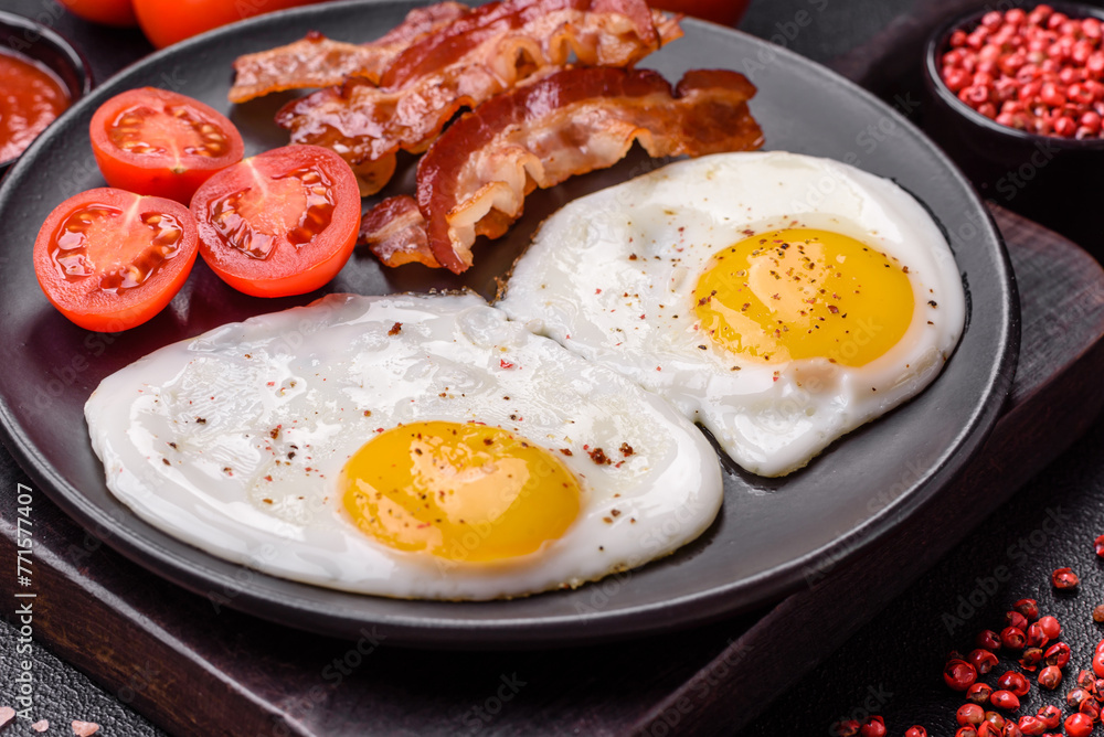 English breakfast with fried eggs, bacon, beans, tomatoes, spices and herbs English breakfast with fried eggs, bacon, beans, tomatoes, spices and herbs