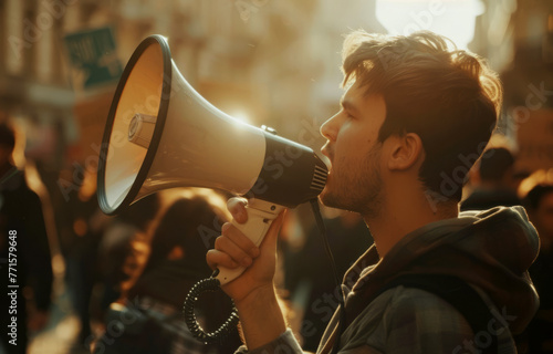 A man with a megaphone is shouting into it. The man is surrounded by a crowd of people, some of whom are looking at him.