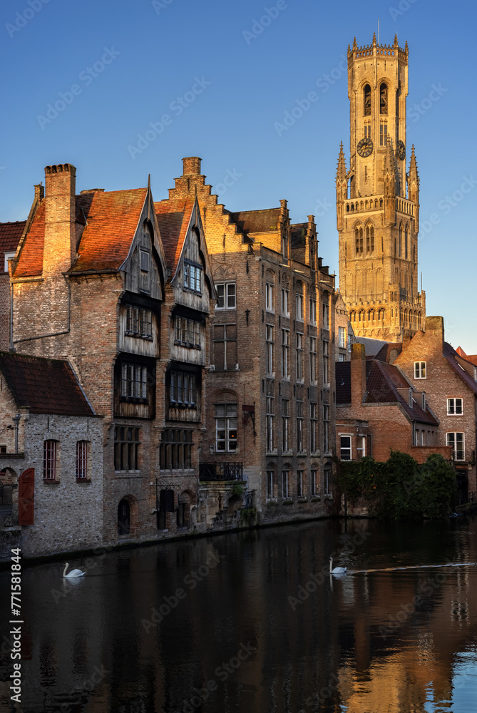 BRUGES, BELGIUM-NOVEMBER 16, 2022:  View from Rozenhoedkaai (the Quay of the Rosary) to the iconic clock tower Belfort (Belfry) and old hanseatic buildings