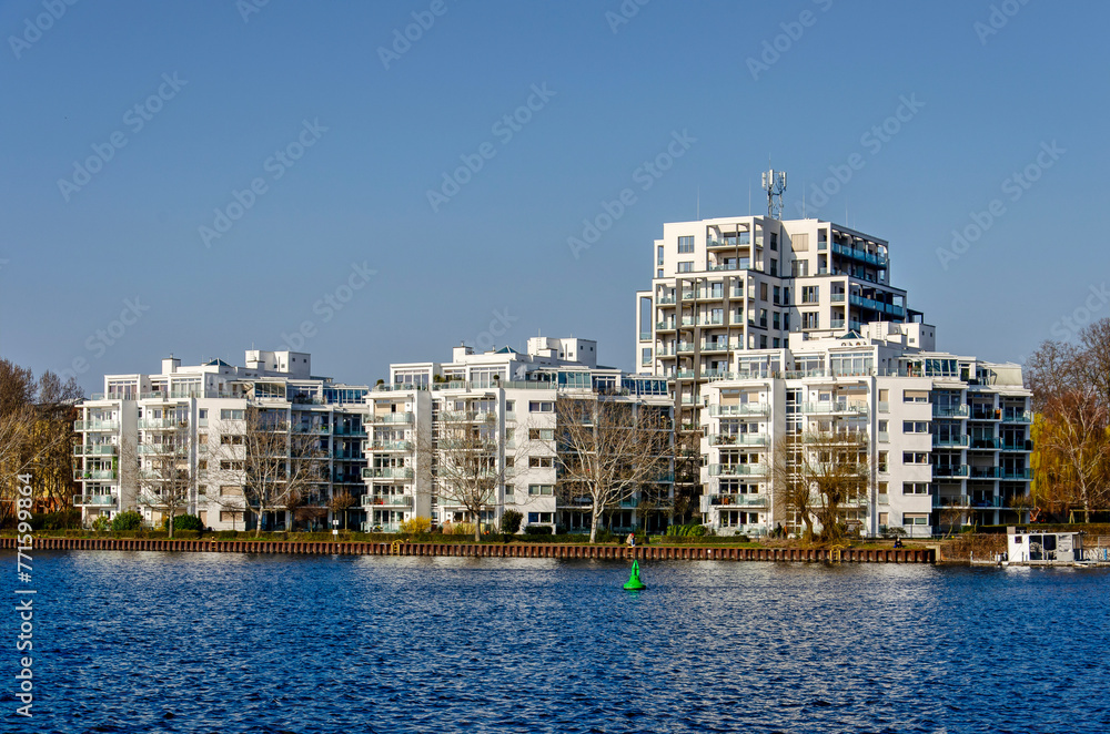 Berlin, Germany, March 7, 2024: view across the river Spree towards a complex of white apartment buildings Berlin, Germany, March 7, 2024: view across the river Spree towards a complex of white apartment buildings