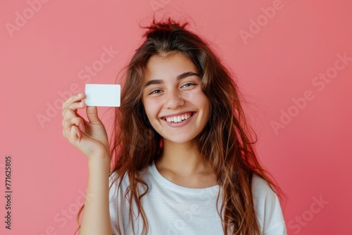 Smiling woman holds her white mockup credit card in her hand Isolated on color background photo