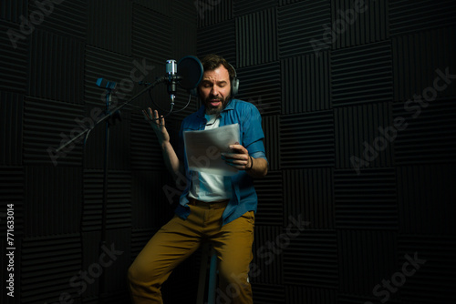 Male voice actor recording in soundproof studio photo