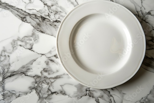 Close-up of an empty white porcelain plate resting on a sleek marble counter
