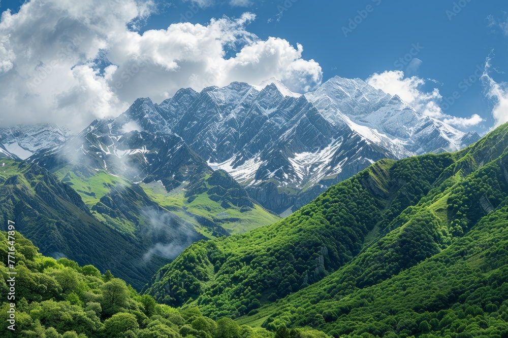 A panoramic shot of a mountain range with snowcapped peaks under a cloudy sky